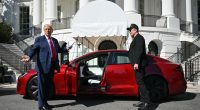 Donald Trump and Elon Musk at the White House next to a red Tesla.