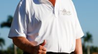 Donald Trump giving a thumbs-up at a golf course.