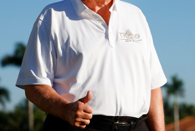 Donald Trump giving a thumbs-up at a golf course.