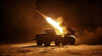 Ukrainian servicemen firing a BM-21 Grad multiple-launch rocket system at night.