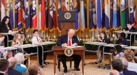 President Trump signing an executive order to shut down the Department of Education, surrounded by children.