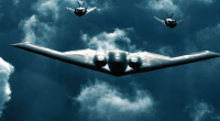 B-2 Spirit bomber with two fighter jets flying in formation.
