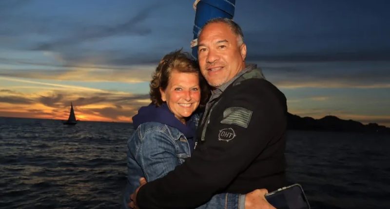 Couple embracing at sunset by the ocean.