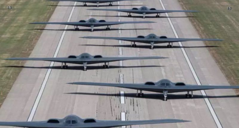 Line of B-2 stealth bombers on a runway.