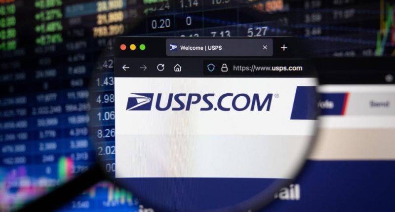 USPS.com website viewed on a computer screen with a blurred stock market in the background.