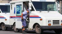 Postal worker exiting a Grumman Long Life Vehicle.
