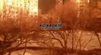 Nighttime view of apartment buildings illuminated by fire.