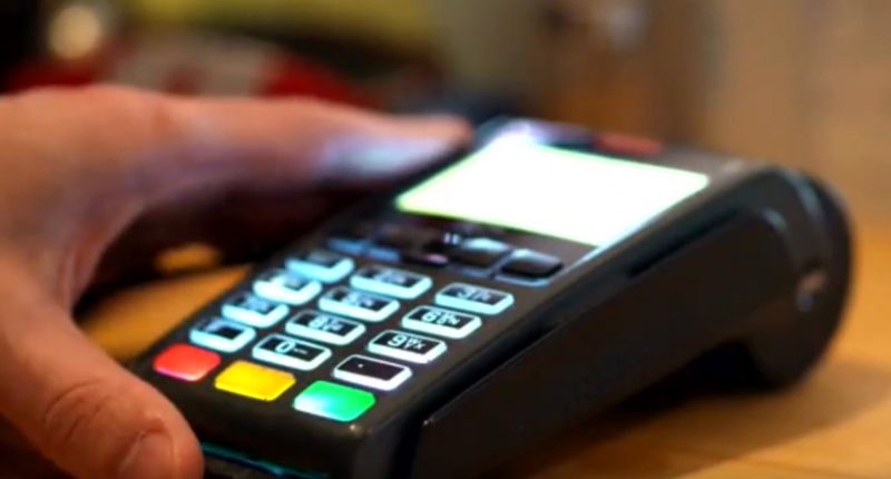 Close-up of a hand using a card reader.