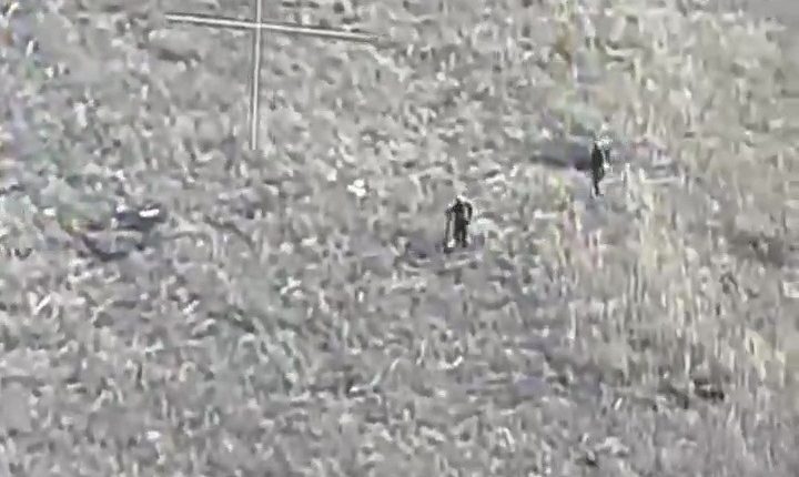 Aerial view of two soldiers on e-scooters.