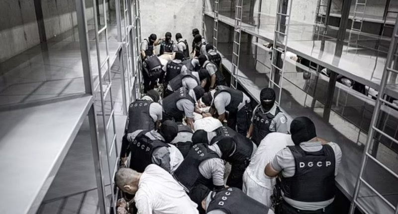Law enforcement officers subduing prisoners in a prison cell block.