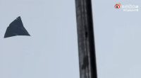 Photo of a dark, triangular object in the sky.