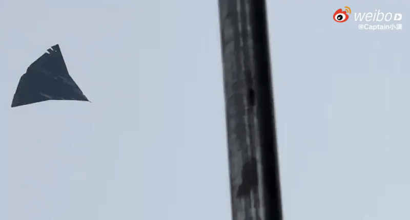 Photo of a dark, triangular object in the sky.