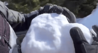 Person packing a large snowball.
