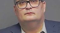 Photo of a man in a suit and glasses.