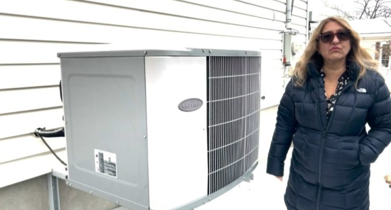 Woman standing next to a Carrier heat pump.