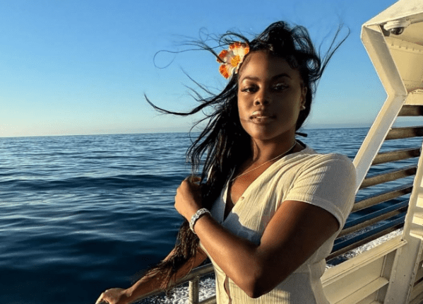 Woman on a boat, looking out at the ocean.