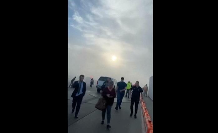 Aircraft catches fire after landing in Denver, sending passengers onto wing as smoke engulfs plane