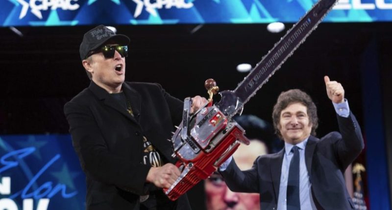 Elon Musk holds a chainsaw handed to him by Argentine President Javier Milei, behind, at the Conservative Political Action Conference (CPAC) in Oxon Hill, Maryland, Feb. 20, 2025. (AP Photo/Jose Luis Magana)