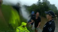 Police wade through deep floodwaters to save woman trapped in car