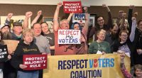 People raise their hands in a show of support for an effort to limit the ability of Missouri lawmakers to change or restrict citizen ballot initiatives after attending a town-hall forum at the Missouri River Regional Library in Jefferson City on Saturday, March 15, 2025. (AP Photo/David A. Lieb)