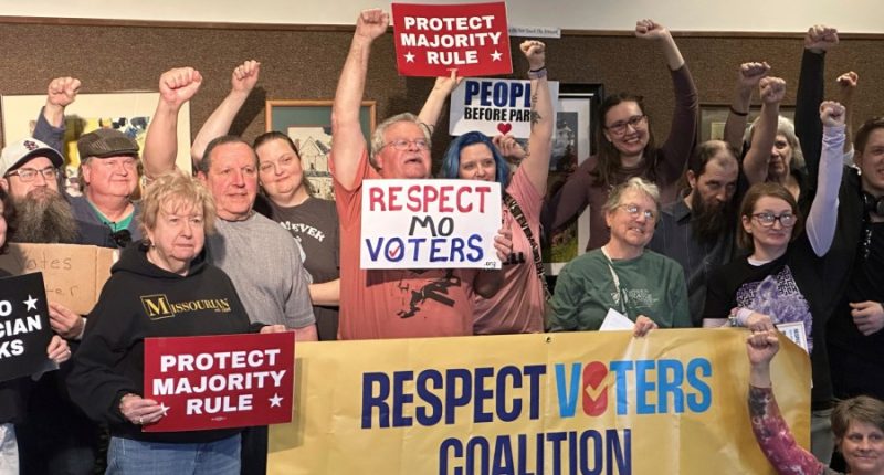 People raise their hands in a show of support for an effort to limit the ability of Missouri lawmakers to change or restrict citizen ballot initiatives after attending a town-hall forum at the Missouri River Regional Library in Jefferson City on Saturday, March 15, 2025. (AP Photo/David A. Lieb)