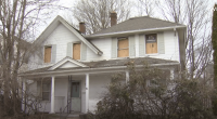 House with boarded-up windows.