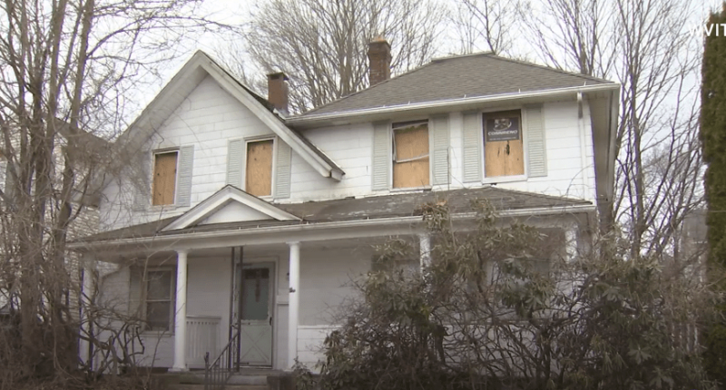 House with boarded-up windows.