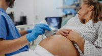 Doctor performing an ultrasound on a pregnant woman.