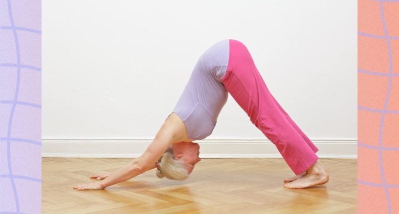 mature woman in purple and pink flowy yoga attire doing downward-facing dog
