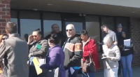 Long line of people waiting outside a building.