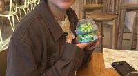 Woman holding a small container with a green bow.