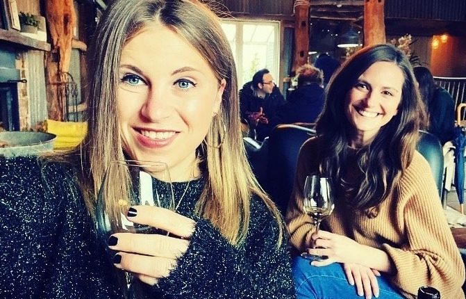 Two women enjoying wine in a restaurant.