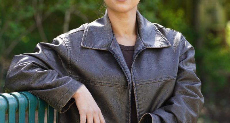 Portrait of Majda Mjaoual sitting on a park bench.
