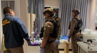 Police officers in a hotel room investigating a crime scene.