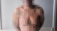 Photo of a shirtless man in police custody.