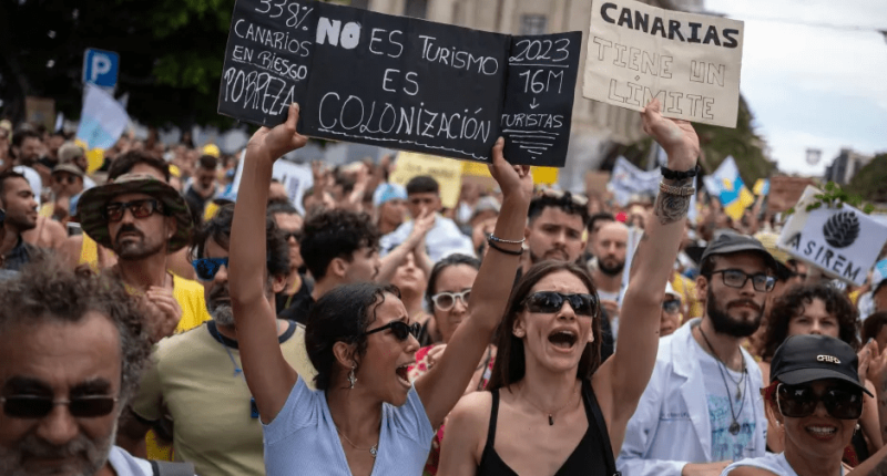 Protestors holding signs about overtourism in the Canary Islands.