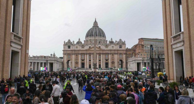 Large crowd of people queueing in St. Peter's Square to pay respects to Pope Francis.