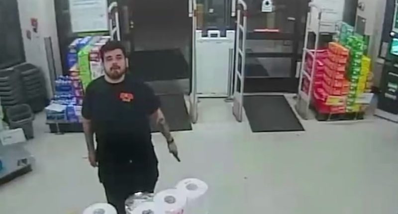 Security camera footage of a man holding a gun in a Walgreens store.