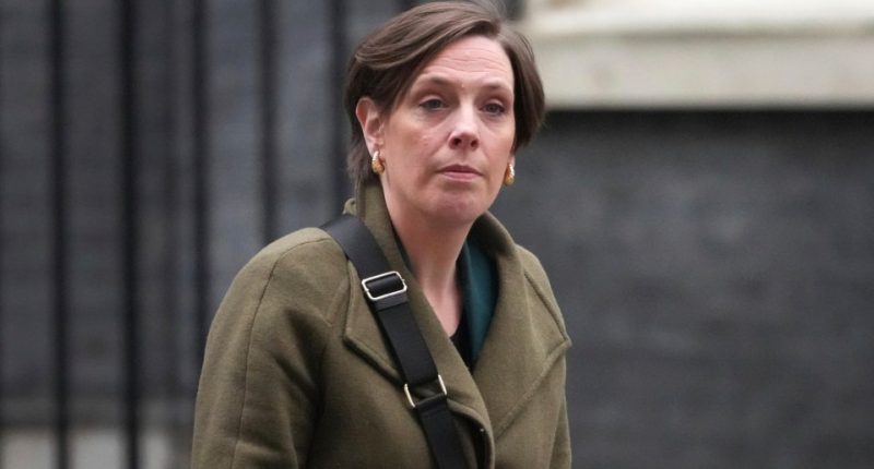 Jess Phillips, UK Parliamentary Under-Secretary of State for Safeguarding and Violence Against Women and Girls, using a mobile phone.