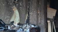 Fire damage to a room, showing charred walls and furniture.