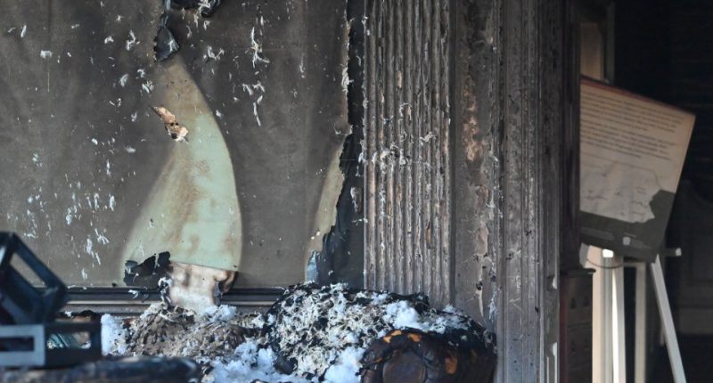 Fire damage to a room, showing charred walls and furniture.