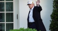 President Donald Trump waving outside the White House.
