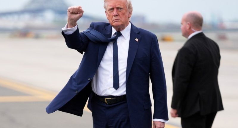President Trump at an airport, raising his fist.