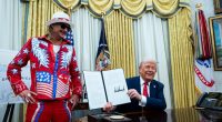 President Donald Trump and Kid Rock in the Oval Office; Trump is signing an executive order.