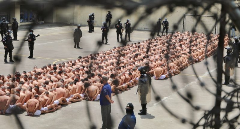 a large group of people are lined up in a prison yard