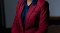 Portrait of Kemi Badenoch in a red suit.