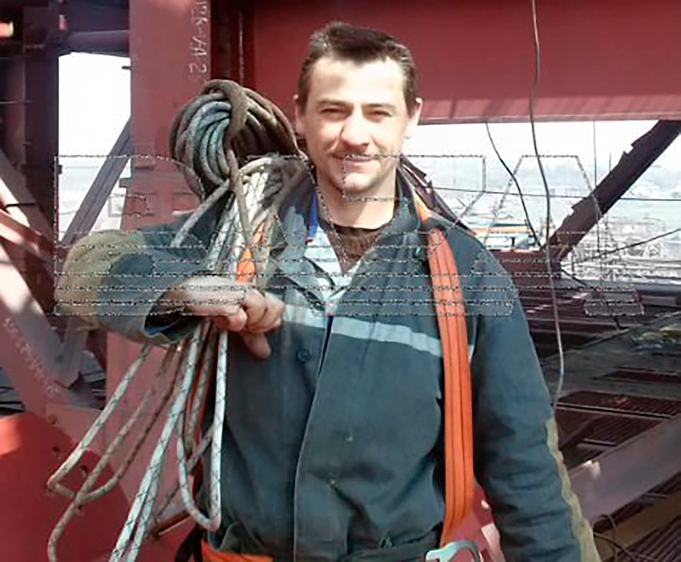 Worker carrying rope on a construction site.