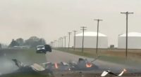 Plane crash on a road near some storage tanks.