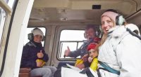 Family of five giving thumbs up inside a helicopter.