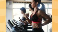 fit brunette woman running on treadmill at gym in line of treadmills